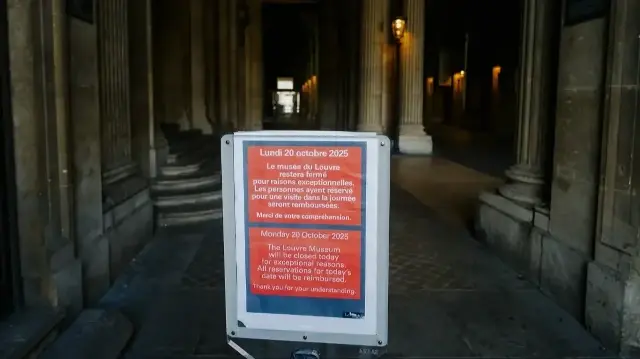 Une affiche annonçant la fermeture et un panneau d'avertissement sont visibles dans la cour de la pyramide du Louvre, suite au vol de bijoux inestimables commis la veille dans le musée parisien, à Paris, le 20 octobre 2025. 