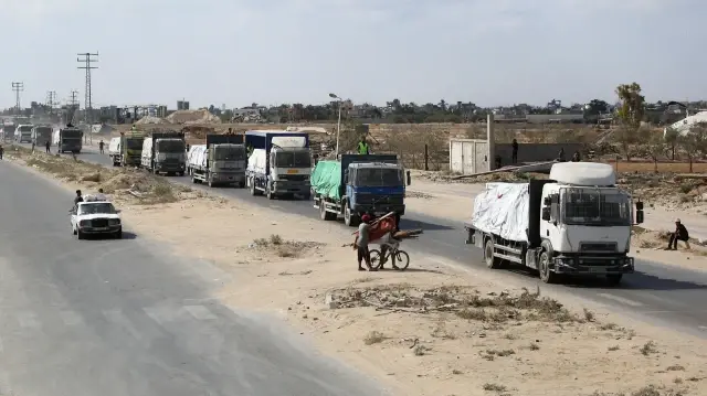 Des camions transportant l'aide fournie par le Programme alimentaire mondial (PAM) roulent sur une route à Deir el-Balah après avoir franchi le poste-frontière de Kerem Shalom, dans le sud de la bande de Gaza, le 17 octobre 2025.