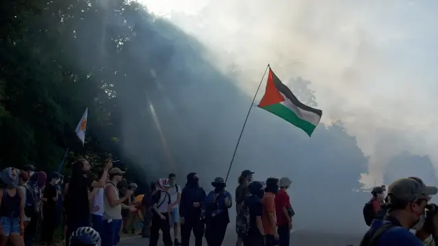 Un manifestant brandit le drapeau palestinien au milieu des nuages de gaz lacrymogène. Les opposants au projet d'autoroute A69 se rassemblent dans le département du Tarn, à Maurens-Scopont, en France, le 6 juillet 2025.