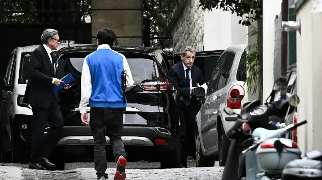L'ancien président français Nicolas Sarkozy (à droite) sort d'un véhicule alors qu'il rentre chez lui, accompagné de son avocat Jean-Michel Darrois (à gauche), à Paris, le 13 octobre 2025, après avoir rencontré les procureurs pour être informé du début de sa peine de prison, après avoir été condamné le mois dernier à cinq ans de prison pour association de malfaiteurs.