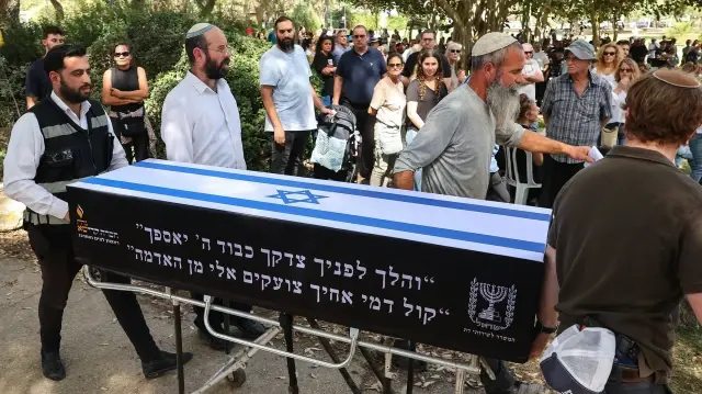 Les proches de Ronen Engel, un Israélien enlevé à son domicile et tué par des militants palestiniens lors des attaques du Hamas contre Israël le 7 octobre 2023, portent son cercueil lors de ses funérailles au kibboutz de Nir Oz, dans le sud d'Israël, le 21 octobre 2025.