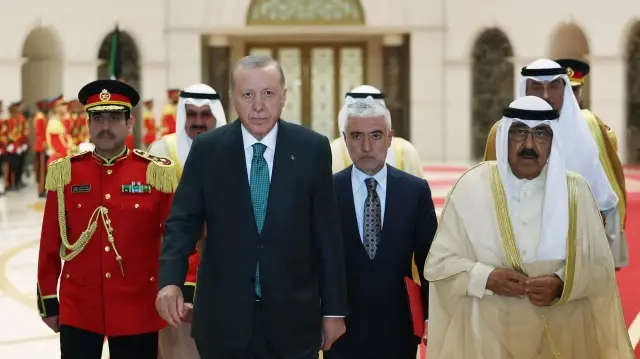 Cette photo prise et diffusée par le service de presse de la présidence turque le 21 octobre 2025 montre l'émir du Koweït, Cheikh Meshal al-Ahmad al-Sabah (à droite), saluant le président turc Recep Tayyip Erdogan (au centre à gauche) à Koweït City, lors de la visite officielle de ce dernier au Koweït.