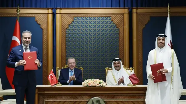 Cette photo prise et diffusée par le service de presse de la présidence turque le 22 octobre 2025 montre (de gauche à droite) le ministre turc des Affaires étrangères Hakan Fidan, le président turc Recep Tayyip Erdogan, l'émir du Qatar Cheikh Tamim bin Hamad al-Thani et le ministre qatari des Affaires étrangères Cheikh Mohammed bin Abdulrahman bin Jassim al-Thani assistant à une cérémonie de signature d'accords lors d'une visite officielle à Doha. 
