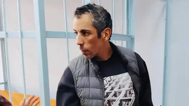 Sur cette photo prise le 23 octobre 2025 et diffusée par le service de presse commun des tribunaux de la région du Kraï de Primorié, le cycliste français Sofiane Sehili, arrêté pour avoir franchi illégalement la frontière russe alors qu'il tentait de battre le record du monde de traversée de l'Eurasie à vélo, se tient dans une salle d'audience après avoir été condamné à une amende de 50 000 roubles (530 euros) puis libéré sans la payer, dans la localité extrême-orientale de Pogranichnyy.