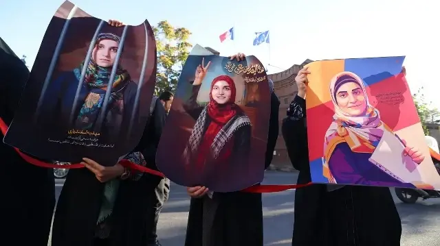 Des manifestants brandissent des portraits de Mahdieh Esfandiari, une Iranienne arrêtée en France en février lors d'un rassemblement appelant à sa libération, devant l'ambassade de France à Téhéran, le 21 octobre 2025.