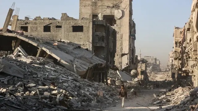 Un Palestinien marche parmi les décombres des bâtiments détruits dans le quartier de Sheikh Radwan, à Gaza, le 22 octobre 2025.