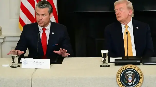 Le président américain Donald Trump écoute le secrétaire à la Défense Pete Hegseth lors d'une table ronde sur l'application de la loi dans la salle à manger d'État de la Maison Blanche, le 23 octobre 2025 à Washington, DC.