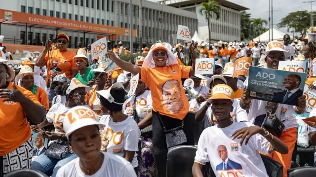 Des partisans chantent et dansent lors d'un rassemblement politique en faveur du président ivoirien et candidat à la présidence pour le Rassemblement des Houphouëtistes pour la démocratie et la paix (RHDP), Alassane Ouattara, place de la République à Abidjan, le 23 octobre 2025, à l'approche de l'élection présidentielle.