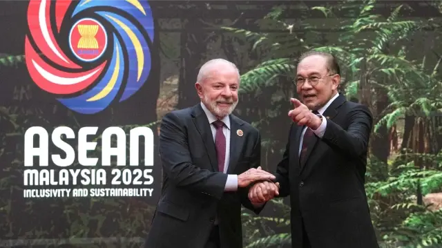 Le Premier ministre malaisien Anwar Ibrahim (à droite) serre la main du président brésilien Luiz Inacio Lula da Silva à son arrivée au 47e sommet de l'Association des nations de l'Asie du Sud-Est (ASEAN) à Kuala Lumpur, le 26 octobre 2025.