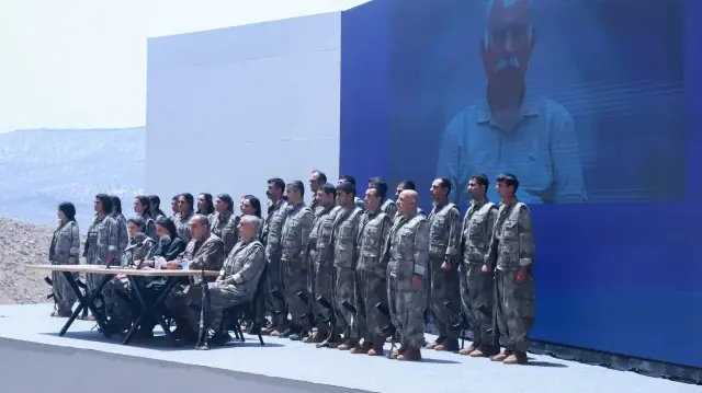 Des commandants et des combattants du Parti des travailleurs du Kurdistan (PKK) se tiennent devant une photo du leader emprisonné et fondateur du PKK, Abdullah Öcalan, lors d'une cérémonie à Souleimaniye, dans la région autonome du Kurdistan irakien, le 11 juillet 2025. Le PKK, groupe militant kurde, a annoncé le retrait de toutes ses forces de Türkiye vers le nord de l'Irak le 26 octobre 2025, dans un communiqué publié par l'agence de presse Firat.