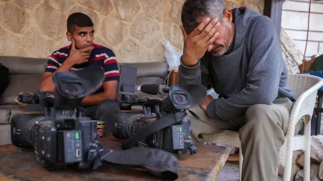 Des membres de la presse pleurent après une frappe israélienne qui aurait touché une maison utilisée par des journalistes dans la ville d'Al-Zawayda, près de Deir al-Balah, dans le centre de Gaza, le 19 octobre 2025.