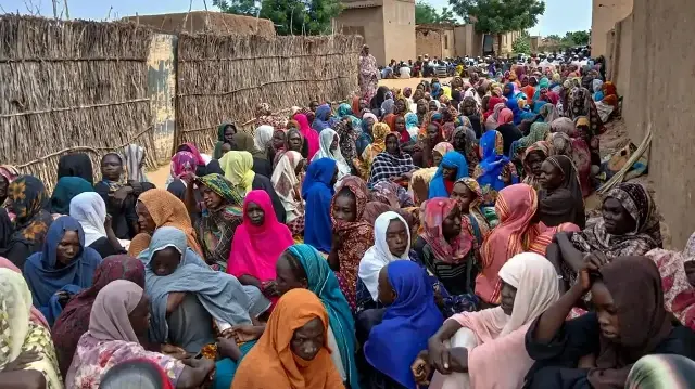 Des habitants soudanais se rassemblent pour recevoir des repas gratuits à Al Fasher, une ville assiégée depuis plus d'un an par les Forces de soutien rapide (RSF), une milice paramilitaire soudanaise, dans la région du Darfour, le 11 août 2025.