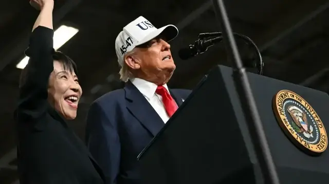 La Première ministre japonaise Sanae Takaichi (à gauche) fait un geste tandis que le président américain Donald Trump prononce un discours devant le personnel de la marine américaine à bord du porte-avions USS George Washington de la marine américaine à la base navale américaine de Yokosuka, le 28 octobre 2025. 