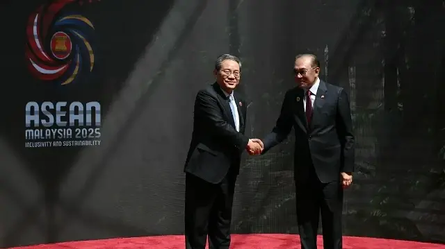 Le Premier ministre chinois Li Qiang (à gauche) serre la main du Premier ministre malaisien Anwar Ibrahim à son arrivée au Centre des congrès de Kuala Lumpur pour assister au 47e sommet de l'Association des nations de l'Asie du Sud-Est (ASEAN) à Kuala Lumpur, le 27 octobre 2025.