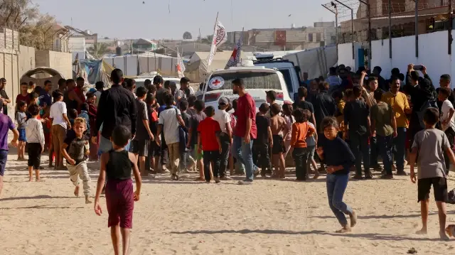 Des personnes se rassemblent autour des véhicules du Comité international de la Croix-Rouge (CICR) à Khan Yunis, dans le sud de la bande de Gaza, le 26 octobre 2025.