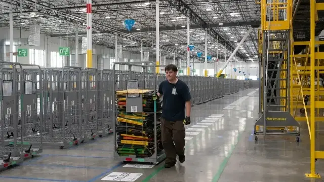 Un employé transporte des sacs de tri à la station de livraison DUR3 d'Amazon à Milpitas, en Californie, le 22 octobre 2025.