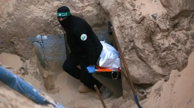 Un militant du Hamas transporte un corps retrouvé dans un tunnel au nord de Khan Yunis, dans le sud de la bande de Gaza, le 28 octobre 2025. Le 28 octobre, l'armée israélienne a accusé le Hamas d'avoir mis en scène la recherche du corps d'un otage de Gaza, l'un des 28 que le groupe avait accepté de remettre dans le cadre d'un accord de cessez-le-feu.