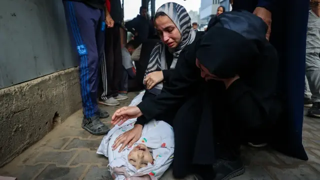 Des femmes pleurent sur le corps d'un enfant tué lors d'une frappe israélienne, à Nuseirat, dans le centre de la bande de Gaza, le 29 octobre 2025.