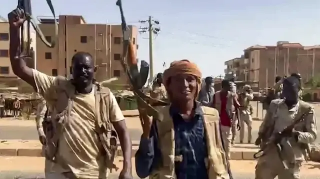 Sur cette image tirée d'une vidéo diffusée par les Forces de soutien rapide (RSF), une milice soudanaise, le 23 avril 2023, des combattants brandissent des fusils d'assaut alors qu'ils traversent une rue dans le district d'East Nile, dans la banlieue de Khartoum.