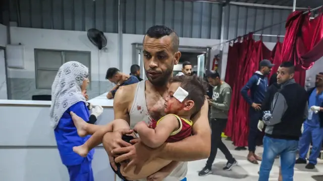 Un homme transporte un enfant blessé lors d'une frappe israélienne à l'hôpital Al-Awda de Nuseirat, dans le centre de la bande de Gaza, le 29 octobre 2025. L'agence de défense civile de Gaza a déclaré à l'AFP le 29 octobre que des dizaines de frappes israéliennes avaient tué au moins 50 personnes dans le territoire palestinien pendant la nuit, quelques heures après que le président américain Donald Trump ait déclaré que "rien" ne compromettrait l'accord de cessez-le-feu qu'il avait contribué à négocier. 

