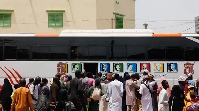Les amis et les proches d'Aboubakar Cissé se tiennent à côté d'un bus en direction de son village natal de Yelimane, devant la mosquée Garantiguibougou à Bamako, le 8 mai 2025. Une cérémonie de prière a eu lieu jeudi à Bamako en hommage à Aboubakar Cissé, un jeune Malien tué dans une mosquée, après que son corps ait été rapatrié dans son pays d'origine pour y être inhumé. 