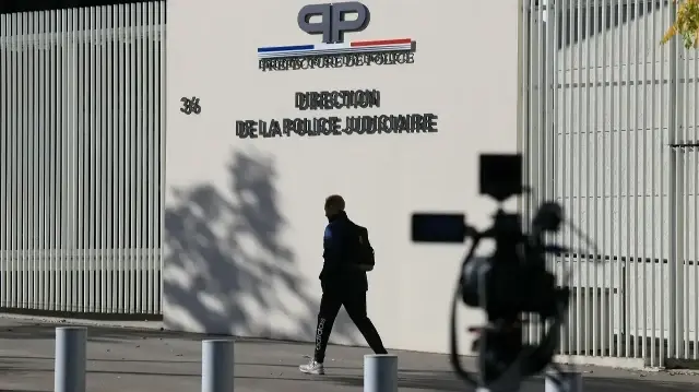 Un piéton passe devant le siège de la Brigade de répression du banditisme (BRB) et de la Direction régionale de la police judiciaire de Paris après l'arrestation de deux suspects dans le cadre de l'enquête sur le vol au Louvre, à Paris, le 26 octobre 2025.