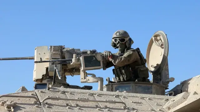 Cette photo prise lors d'une visite organisée par l'armée israélienne le 3 octobre 2025 montre un soldat israélien derrière une mitrailleuse montée à proximité de l'hôpital de campagne jordanien à Gaza.