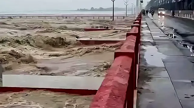 Cette capture d'écran tirée d'une vidéo UGC fournie par l'utilisateur Facebook Bachelal Mukhiya, prise et reçue le 5 octobre 2025, montre de hautes vagues déferlant sur le barrage de Koshi à Bhardaha, dans le district de Saptari, province de Madhesh, après que la rivière Koshi ait débordé en raison de fortes pluies. 