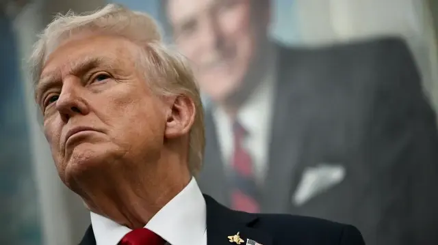 Un portrait de l'ancien président américain Ronald Reagan est accroché derrière le président américain Donald Trump alors que ce dernier fait une annonce sur les médicaments sur ordonnance dans le bureau ovale de la Maison Blanche à Washington, DC, le 30 septembre 2025.