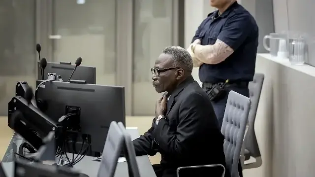 L'ancien commandant en chef de la milice soudanaise Janjaweed, Ali Muhammad Ali Abd-Al-Rahman (au centre), également connu sous le nom d'Ali Kushayb, comparaît devant la Cour pénale internationale de La Haye, le 19 octobre 2023, pour répondre d'accusations de crimes de guerre et de crimes contre l'humanité commis pendant le conflit du Darfour en 2003-2004.