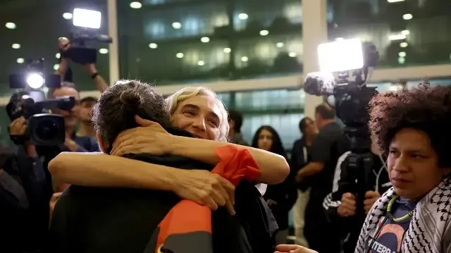 L'ancienne maire de Barcelone, Ada Colau, qui naviguait à bord d'un navire de la flottille Global Sumud, est embrassée à son arrivée à l'aéroport de Barcelone le 5 octobre 2025, après qu'Israël ait intercepté la flottille d'aide humanitaire à destination de Gaza et arrêté des centaines de personnes.