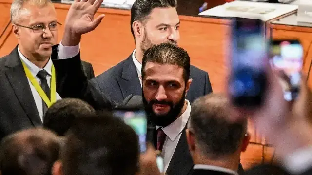 Le président par intérim syrien Ahmed al-Sharaa se rend dans un bureau de vote où les membres des comités locaux syriens ont voté dans le cadre du processus de sélection visant à désigner un parlement provisoire, à Damas, le 5 octobre 2025.