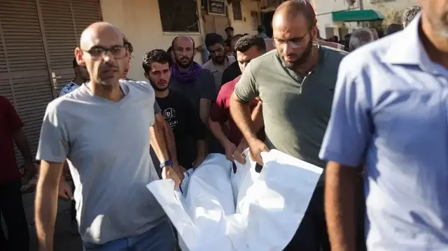 Des Palestiniens transportent le corps d'une victime des frappes israéliennes à Deir al-Balah, à l'hôpital Al-Aqsa Martyrs, dans le centre de la bande de Gaza, le 2 octobre 2025.
