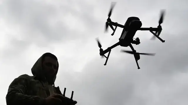 Un militaire ukrainien pilote un drone lors de la compétition de course de drones "Wild Drones", qui simule des conditions de combat, à Kamianets-Podilskyi, dans la région de Khmelnytsky, le 5 octobre 2025, alors que la Russie envahit l'Ukraine.