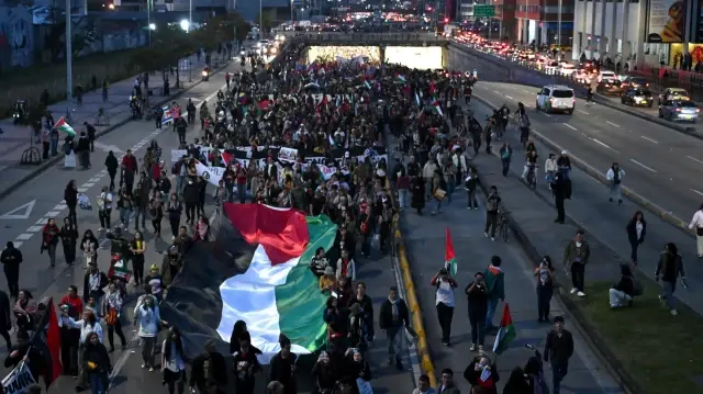 Un manifestant brandit un immense drapeau palestinien lors d'une marche à Bogota, le 7 octobre 2025.