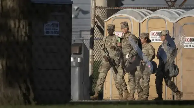 Des membres de la Garde nationale du Texas portent des fusils et des boucliers anti-émeutes dans un centre d'entraînement de la réserve militaire, le 7 octobre 2025 à Elwood, dans l'Illinois. 