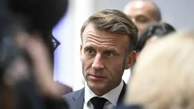 Le président français Emmanuel Macron (au centre) s'entretient avec des personnes lors d'une réception organisée dans le cadre des célébrations centrales de la Journée de l'unité allemande à Sarrebruck, dans le sud-ouest de l'Allemagne, le 3 octobre 2025. Le 3 octobre 2025, l'Allemagne célèbre le 35e anniversaire de la réunification allemande.