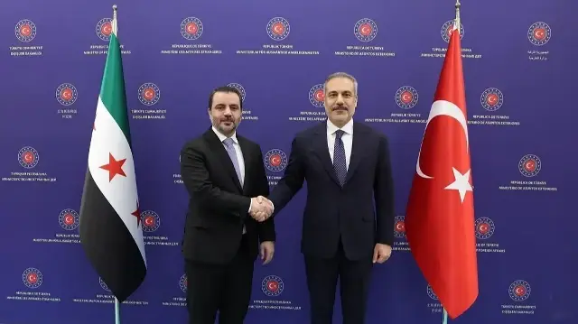 Cette photo prise et diffusée par le service de presse du ministère turc des Affaires étrangères montre le ministre turc des Affaires étrangères Hakan Fidan (à droite) serrant la main du ministre syrien des Affaires étrangères Asaad al-Shaibani à Ankara, le 8 octobre 2025.