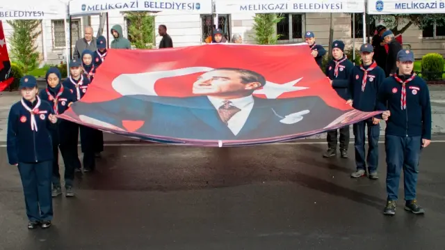 Des participants portent une grande banderole à l'effigie de Mustafa Kemal Atatürk lors des célébrations de la fête nationale à Kayseri, en Türkiye, le 29 octobre 2025.