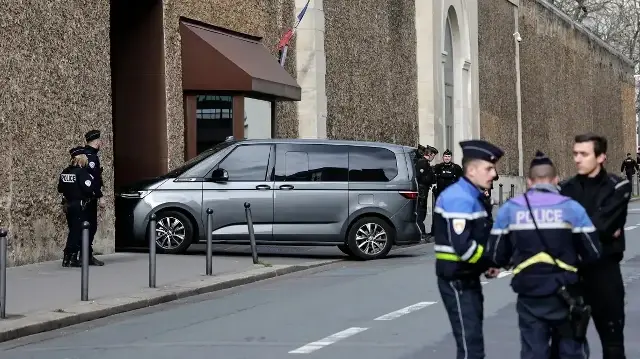 Des policiers montent la garde alors qu'une voiture de police entre dans la prison de Saint-Sulpice à Paris, le 10 novembre 2025.