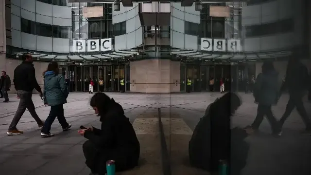 Des gens passent devant l'entrée des bureaux de la BBC à Londres, le 11 novembre 2025.