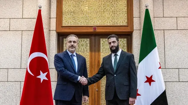 Cette photo diffusée par le service de presse du ministère turc des Affaires étrangères montre le ministre turc des Affaires étrangères Hakan Fidan (à gauche) reçu par le chef de Hayat Tahrir al-Sham (HTS) Ahmed al-Sharaa, à Damas, le 22 décembre 2024.