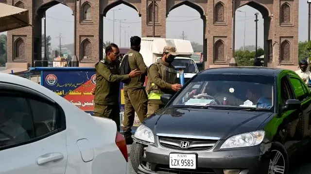 Des policiers fouillent une voiture à un poste de contrôle à Lahore le 12 novembre 2025, au lendemain d'un attentat suicide à Islamabad.