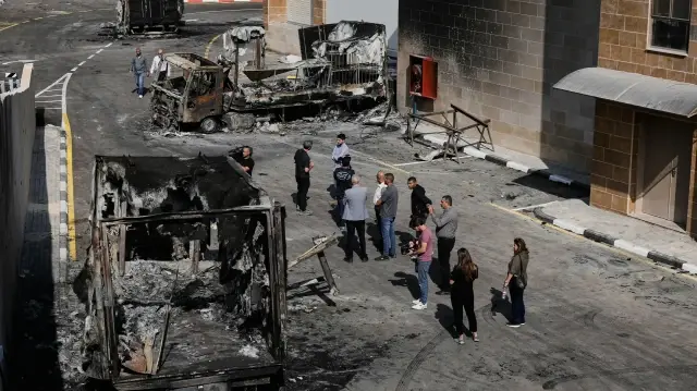 Палестинцы осматривают ущерб, нанесенный промышленной зоне после нападения израильских поселенцев на деревню Бейт-Лид на Западном берегу, недалеко от Тулькарма, 12 ноября.