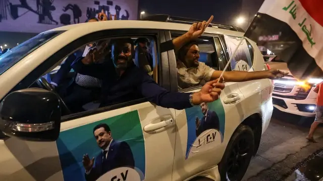 Les partisans du Premier ministre irakien sortant brandissent des drapeaux nationaux pour célébrer l'annonce des résultats préliminaires des élections à Bagdad, le 12 novembre 2025.
