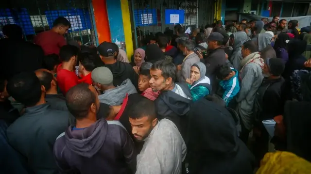 Des centaines de Palestiniens se rassemblent devant le bureau de l'UNRWA à Deir al-Balah, dans la bande de Gaza, dans l'espoir d'obtenir de nouvelles tentes, le 15 novembre 2025.