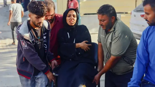 Des Palestiniens portent une femme en deuil lors des funérailles des victimes d'une attaque israélienne à Khan Yunis, dans le sud de la bande de Gaza, le 20 octobre 2025.