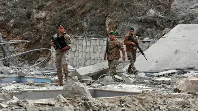 Des soldats de l'armée libanaise inspectent le site d'une frappe aérienne israélienne dans le village de Tair Felsay, situé dans le sud du Liban près du fleuve Litani, tôt le matin du 13 novembre 2025.