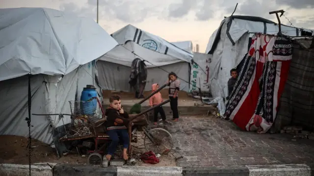 Des enfants palestiniens déplacés jouent devant leur tente dans le port de Gaza, en Palestine, le 16 novembre 2025. 