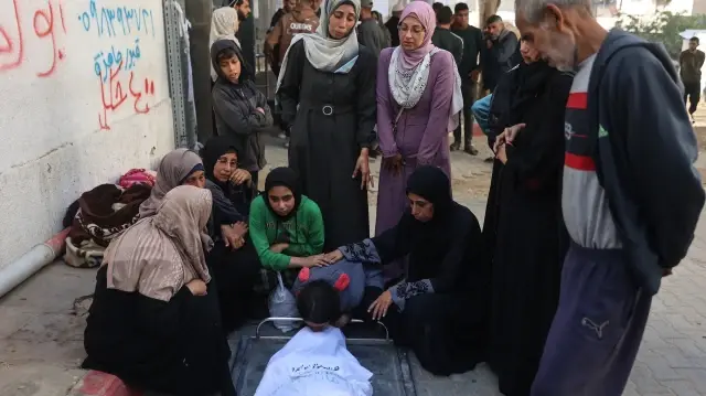 La jeune Palestinienne déplacée Tala Abu Sanra (au centre) pleure sur le corps de sa mère, tuée lors de frappes israéliennes, à l'hôpital Al-Shifa de Gaza, le 20 novembre 2025.